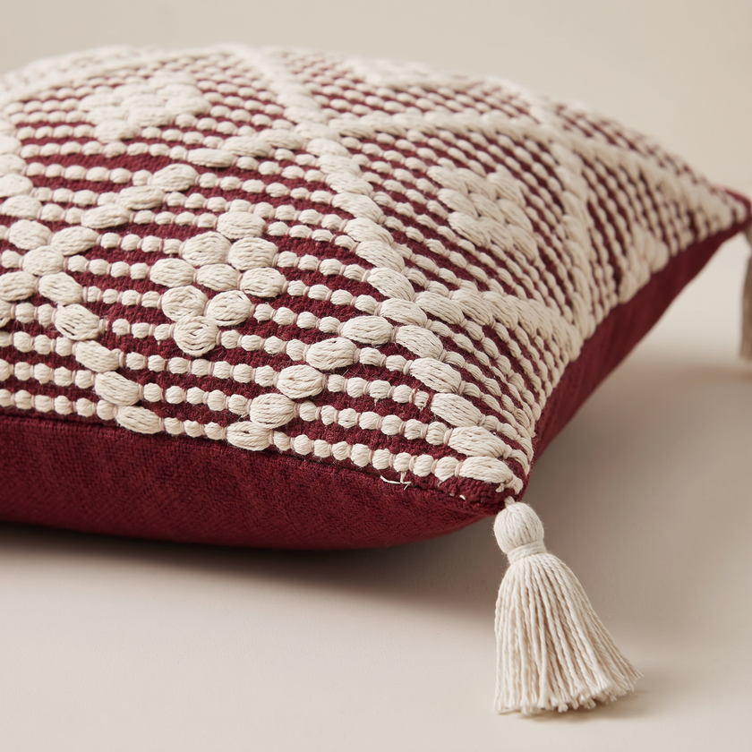 S526 cushion close-up showing ivory woven detail and corner tassel
