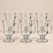 Six Clara 250 ml footed glass cups on a light beige studio background
