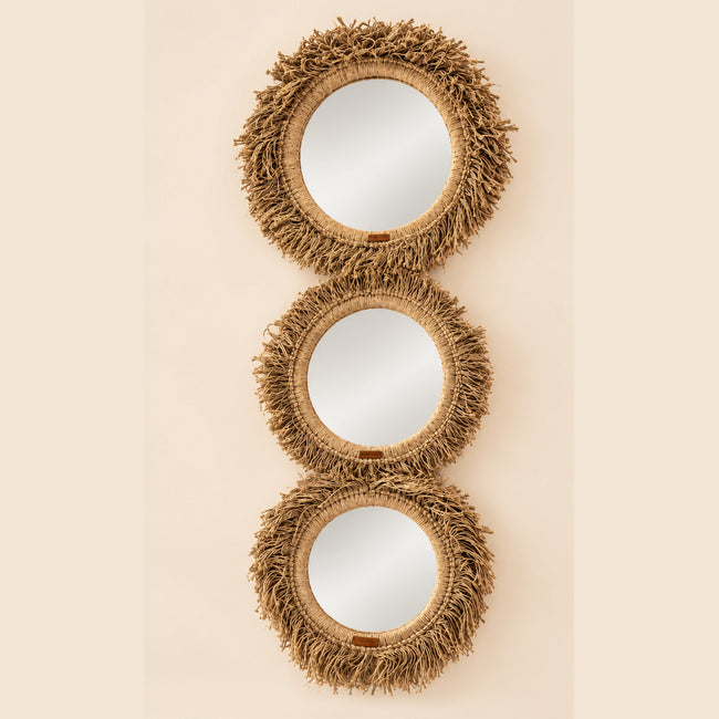 Three natural fringe mirrors on light beige studio background