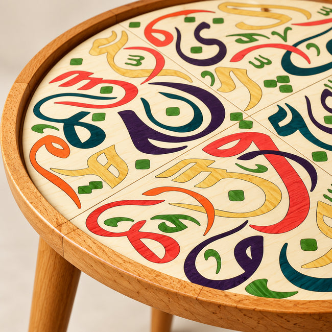 Detail of colorful Arabic calligraphy artwork on natural wooden Huroof table top