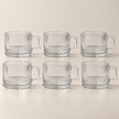 Six Lina transparent 80 ml coffee cups on a light beige studio background