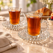 Perla beaded glass cups and saucers filled with amber tea
