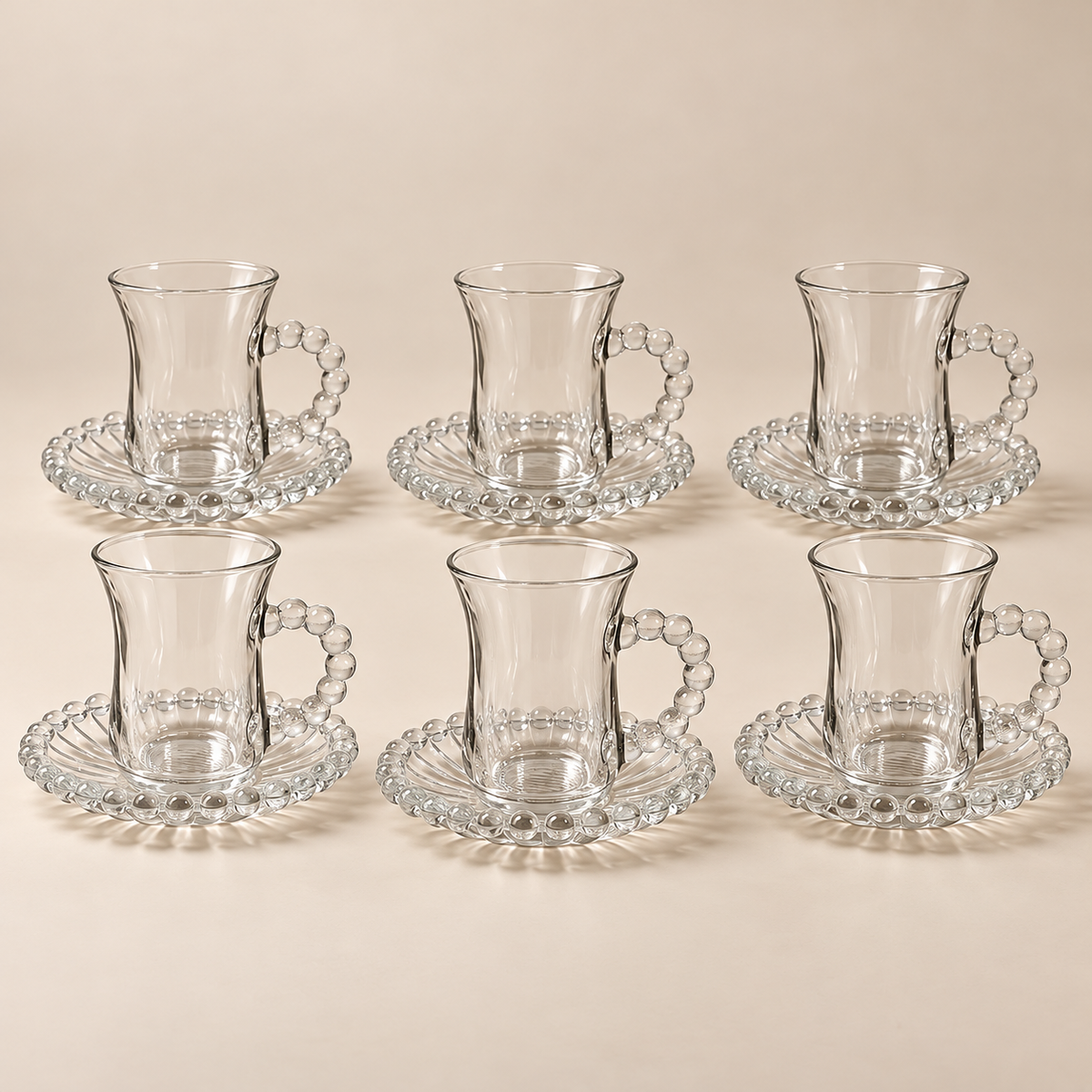Complete Perla set of six 100 ml glass cups and six beaded saucers on light beige