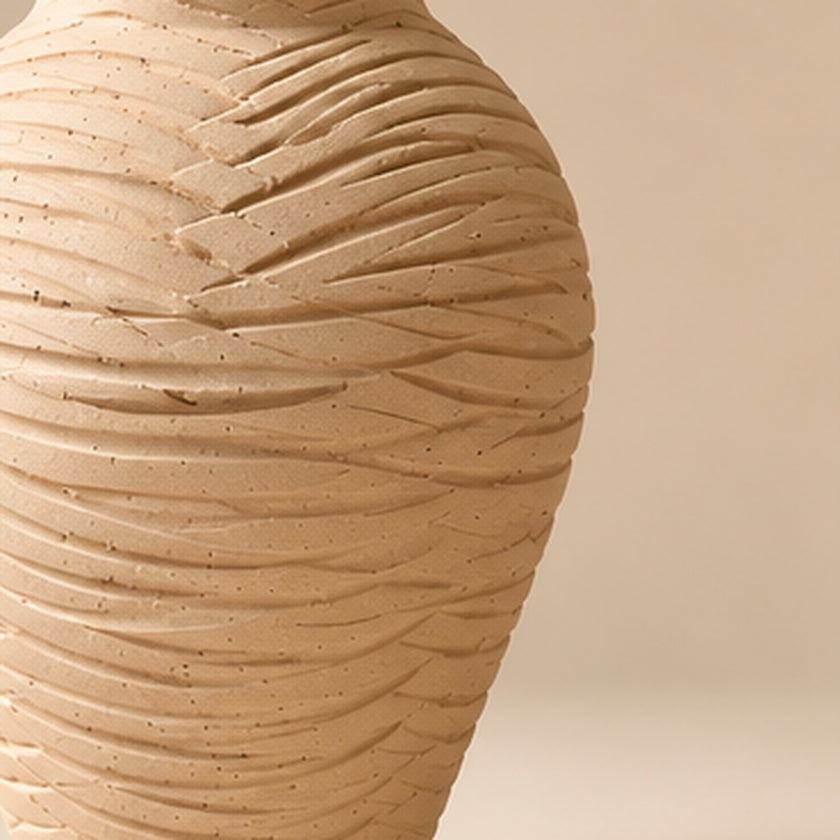 Carved cream pottery vase on a light beige background
