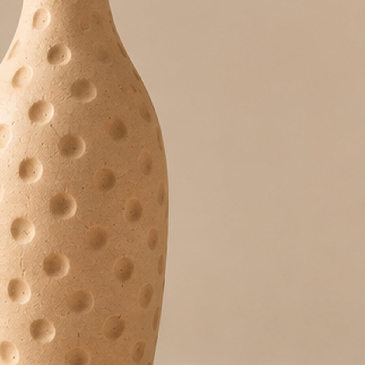 Cream dimpled pottery vase on light beige background