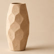 Faceted cream pottery vase on light beige background