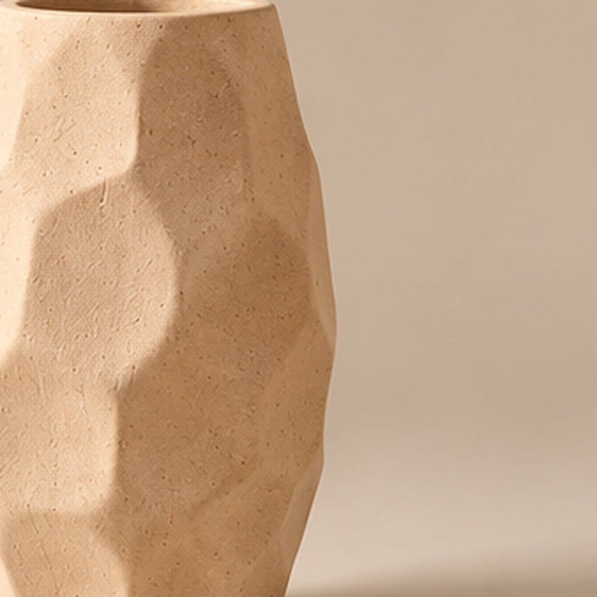 Sand faceted pottery vase on light beige background