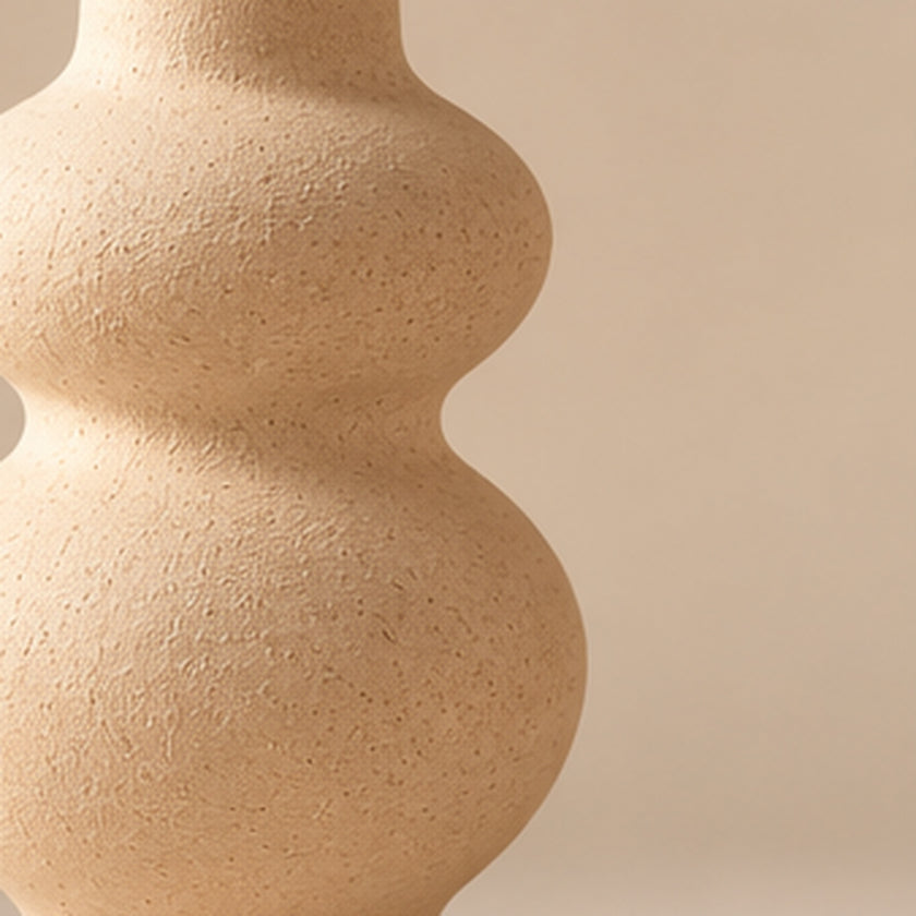 Cream sculptural pottery vase on light beige background